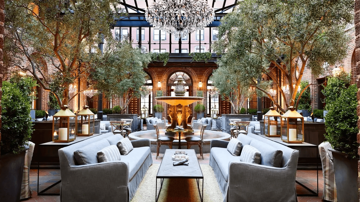 Grand courtyard brewery with olive trees and a crystal chandelier