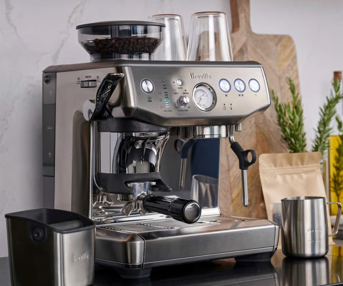 Breville Barista Express espresso machine with grinder, milk jug, and bean bag
