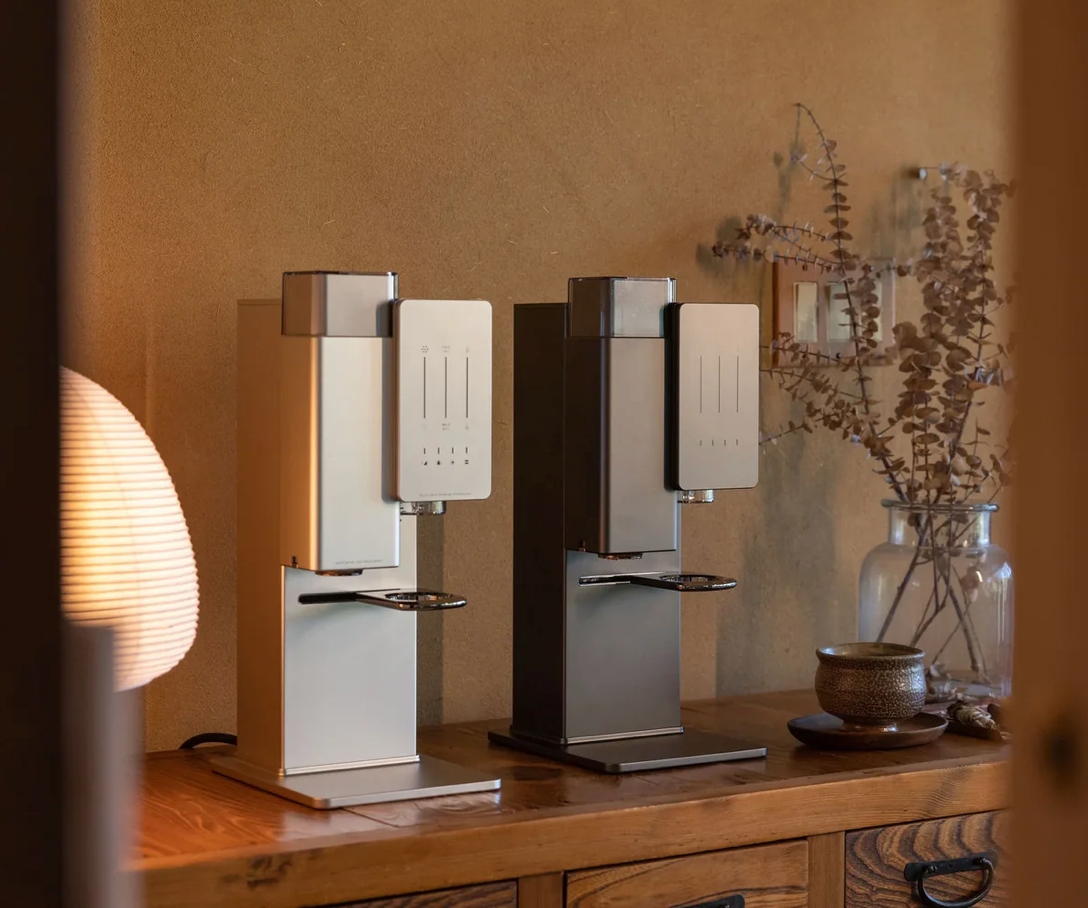 Two xBloom Original pour-over machines side-by-side on a wooden console