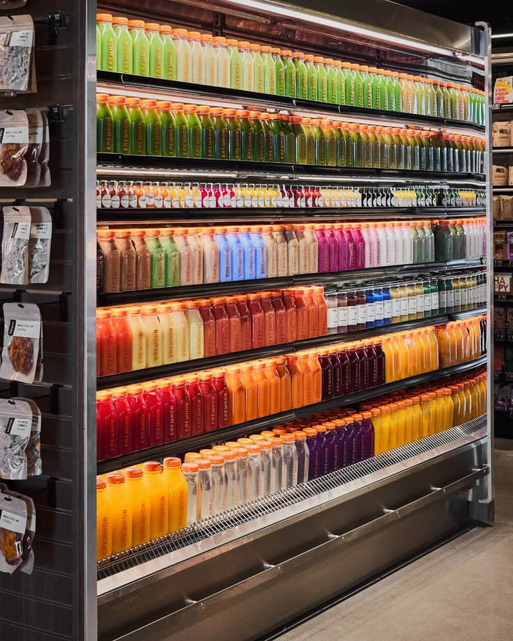 Refrigerated retail shelves filled with colourful bottled drinks